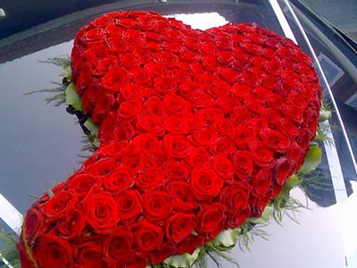 Autoschmuck aus roten Rosen in Herzform