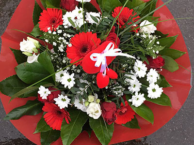 Individuelles Blumengesteck mit weißen und roten Blumen