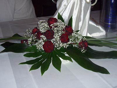 Hochzeitsdeko mit roten Rosen und weißen Blüten