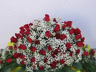 Strauß aus Rosen und weißen Blüten als Sarggesteck