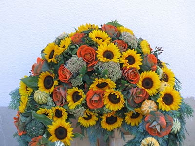 Herbstliches Sarggesteck mit Sonnenblumen und Rosen
